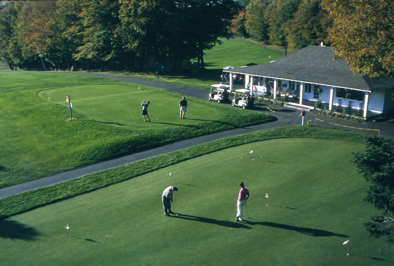 The clubhouse, practice green, and first tee at Saranac Inn Golf Club
