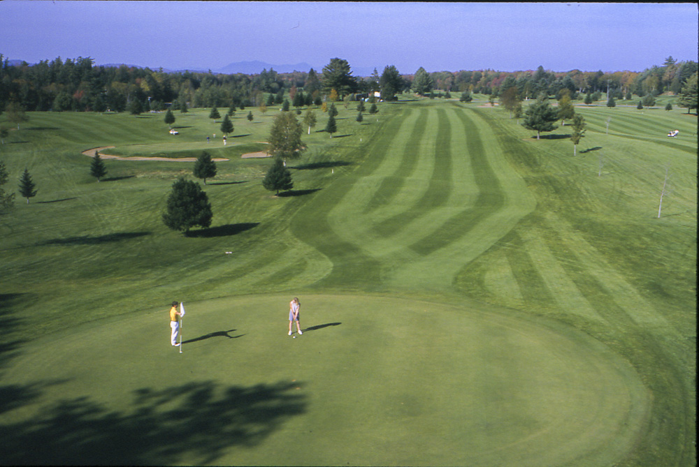 Rolling green framed by mature trees on the Saranac Inn championship course